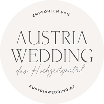 Kreisförmiges Logo mit Text: Empfohlen von Austria Wedding, das Hochzeitsportal für Österreich, Südtirol und die Bodensee-Region, austriawedding.at auf hellem Hintergrund.