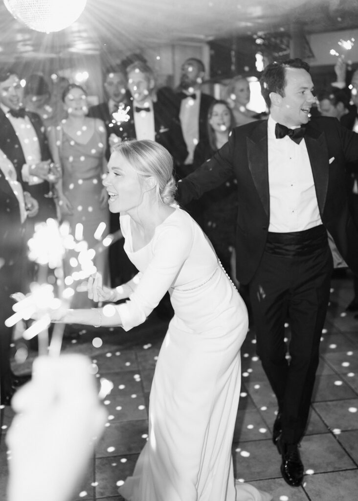 Bride and groom dance happily with guests holding sparklers at a lively wedding celebration in the picturesque Lake Constance region.